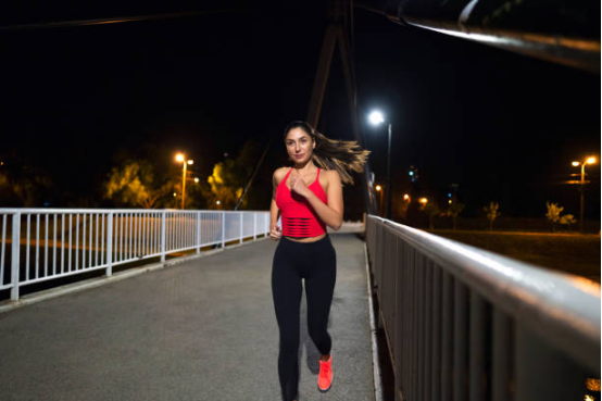 Runner enjoying the flexibility and comfort of yoga pants in the city night.
