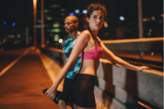 Night runner in yoga pants synchronizing with city lights and rhythm.